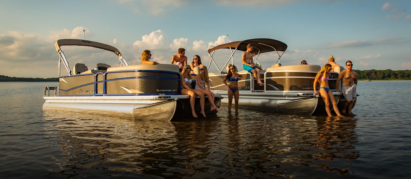 A group of friends on the water sharing two pontoon boats.